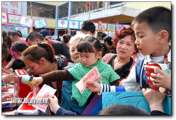 4月27日，婺源縣星星幼兒園的小朋友們?cè)诩议L(zhǎng)的陪同下將愛心義賣的錢進(jìn)行募捐。