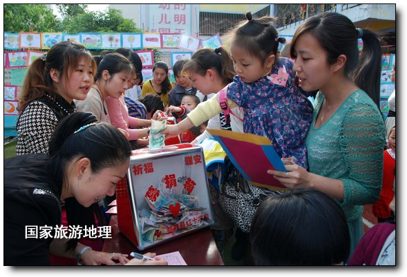 4月27日，婺源縣星星幼兒園的小朋友們?cè)诩议L(zhǎng)的陪同下將愛心義賣的錢進(jìn)行募捐。