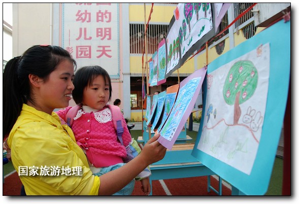 4月27日，婺源縣星星幼兒園的小朋友們?cè)诩议L(zhǎng)的陪同下在挑選愛心義賣的作品。